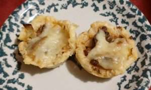 green and white ceramic plate with two wild mushroom tarts in the middle