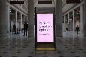 A sign saying Racism is not an Opinion with the hashtag Stop Asian Hate for article on murder hornets
