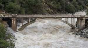 A bridge over the swollen South Yuba River during a flooding event for article on atmospheric rivers