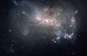 A cluster of stars in a glowing blue and pink haze in the blackness of space. For article on exaptation.